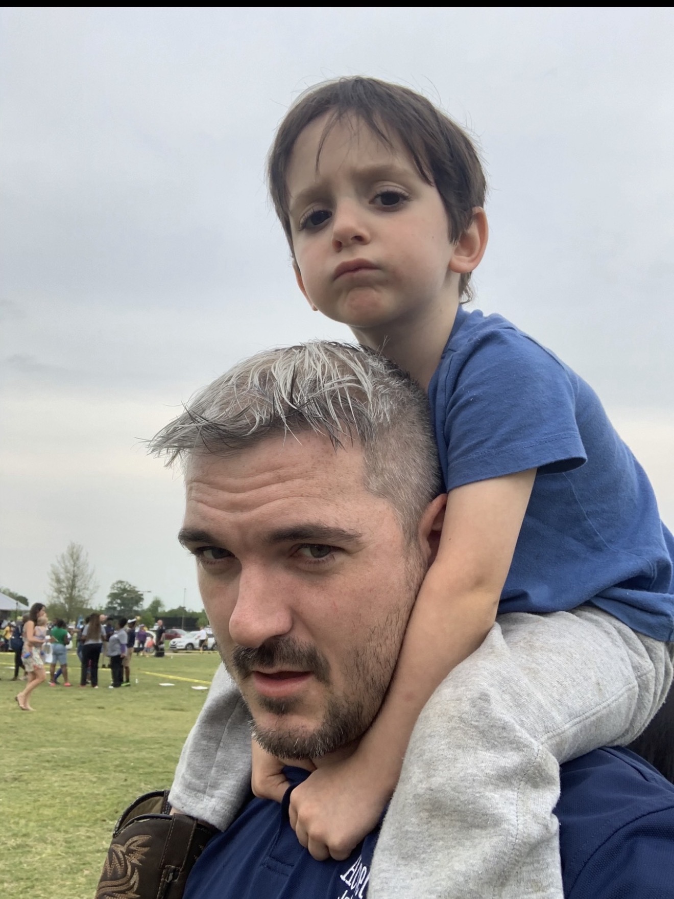 Johnny carrying his son on his shoulders outdoors
