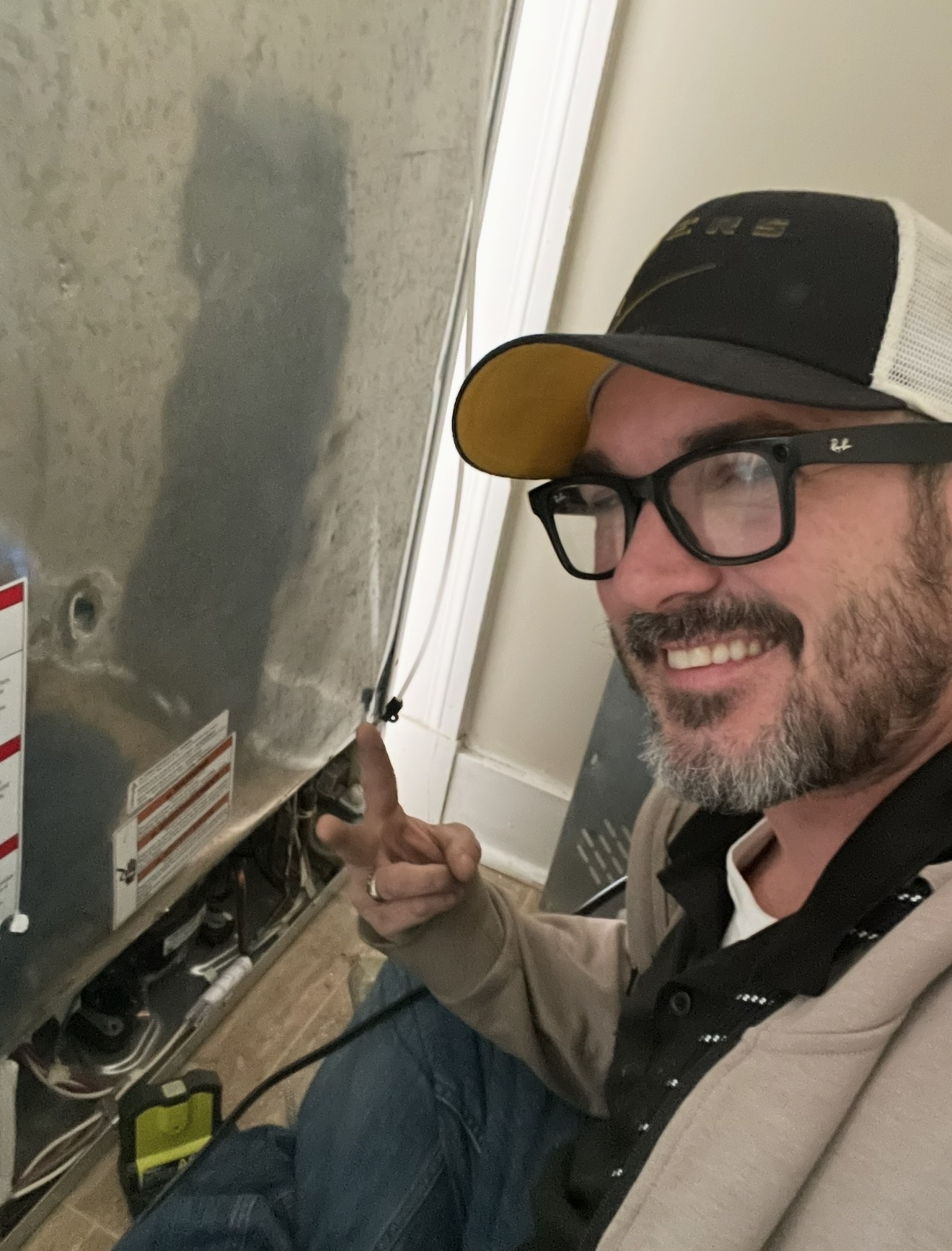 Johnny beside a refrigerator with the rear service panel open